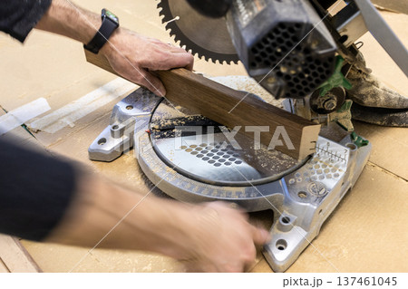 worker cuts baseboard with portable circular saw worker cuts baseboard with portable circular saw 137461045