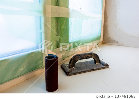 plastering board and sandpaper on plastered sill plastering board and sandpaper on plastered sill 137461065