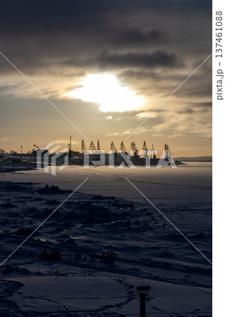 frozen sea shore and port cranes in Kandalaksha 137461088