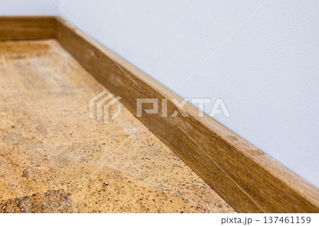 new wooden baseboard on new cork tiles on floor 137461159