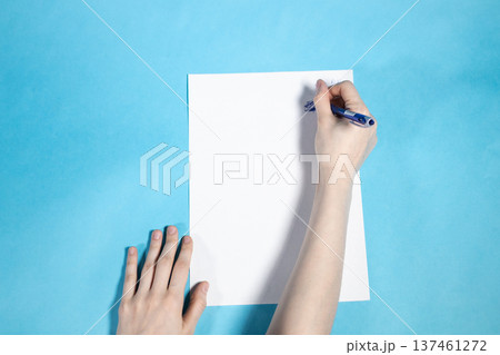 above view of hand writes on blank white paper 137461272