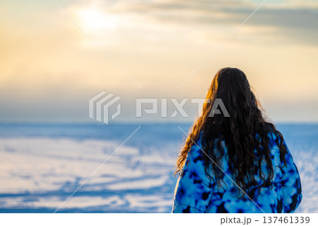 tourist looks on frozen bay on winter sunrise tourist looks on frozen bay on winter sunrise 137461339