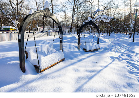 swing covered in deep snow in snowy city park swing covered in deep snow in snowy city park 137461658