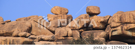 Big balancing granite boulders on a mountain ridge in Basapur, Hampi, India. Big balancing granite boulders on a mountain ridge in Basapur, Hampi, India. 137462314
