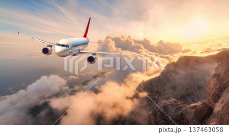 Commercial airplane flying over high mountain peaks and clouds Commercial airplane flying over high mountain peaks and clouds 137463058
