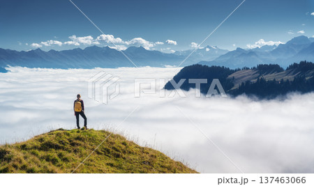 Woman with backpack on mountain ridge above a sea of clouds 137463066