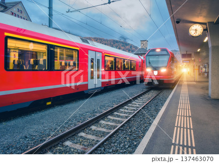 Red modern trains on mountain railway station in Swiss Alps Red modern trains on mountain railway station in Swiss Alps 137463070