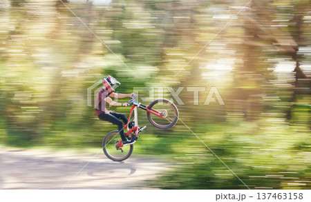 Blur, air and man cycling in nature training for a competition on trail or path in forest or woods. Freedom, stunt or cyclist athlete riding bicycle to jump for cardio exercise, fitness or workout Blur, air and man cycling in nature training for a competition on trail or path in forest or woods. Freedom, stunt or cyclist athlete riding bicycle to jump for cardio exercise, fitness or workout 137463158