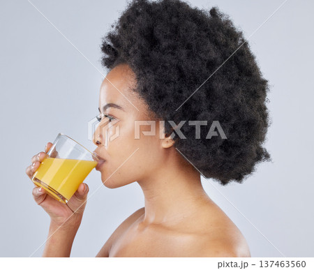 Woman, glass and orange juice in studio for beauty of vitamin c benefits on gray background. Face, african model and drink citrus fruit smoothie for healthy skin, weight loss diet and detox nutrition 137463560