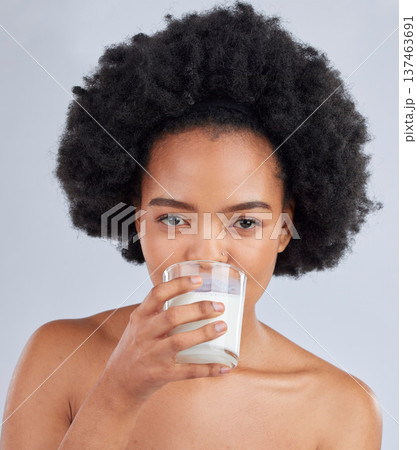 Woman, portrait and drink milk in studio for healthy skin, diet and calcium on white background. Face of african model, dairy smoothie or glass of vanilla milkshake for nutrition, wellness and beauty Woman, portrait and drink milk in studio for healthy skin, diet and calcium on white background. Face of african model, dairy smoothie or glass of vanilla milkshake for nutrition, wellness and beauty 137463691