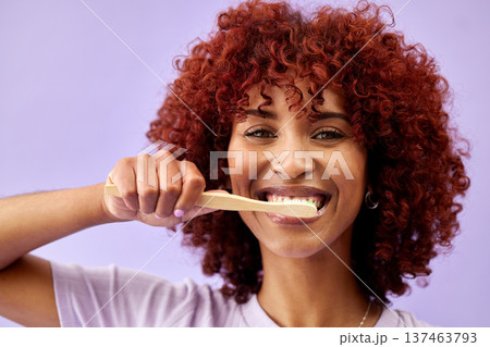 Face, smile and woman brushing teeth with wood in studio isolated on purple background. Portrait, bamboo toothbrush and happy person cleaning for eco friendly hygiene, dental health or sustainability Face, smile and woman brushing teeth with wood in studio isolated on purple background. Portrait, bamboo toothbrush and happy person cleaning for eco friendly hygiene, dental health or sustainability 137463793