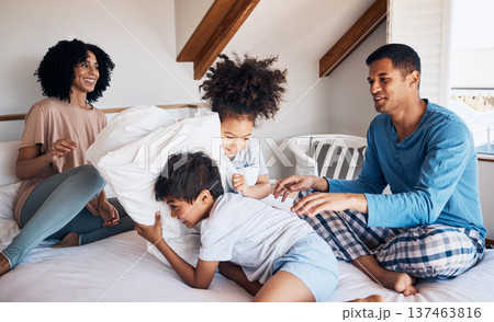 Happy family, parents and children on bed, pillow fight and relax together on weekend morning with fun. Mom, dad and kids in bedroom, playing and bonding in home with love, care and playful games. 137463816