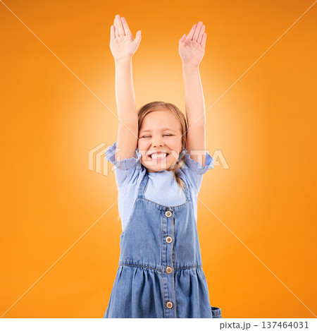 Excited, celebration and girl child with arms up in studio for success, winner or happy on orange background. Yes, news and kid with hands, smile and celebrating achievement, victory or announcement Excited, celebration and girl child with arms up in studio for success, winner or happy on orange background. Yes, news and kid with hands, smile and celebrating achievement, victory or announcement 137464031