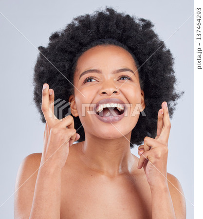 Hope, luck and black woman with fingers crossed for beauty and skincare isolated in a studio gray background with smile. Notification, deal and young person excited for cosmetics with optimism 137464293