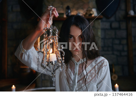 Mysterious woman with damp hair conducts occult ceremony amidst medieval stone walls Mysterious woman with damp hair conducts occult ceremony amidst medieval stone walls 137464416