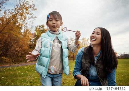 Playful, mom or girl in park with bubbles, happiness or bonding together in child growth. Smile, Asian woman or kid outdoor with blowing fun, healthy relationship or connection in emotional security. 137464532