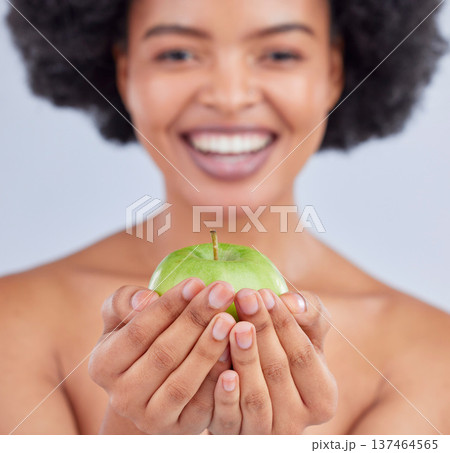 Apple, black woman and hand closeup with health, diet and natural skincare glow in studio. Happy, face and fruit for healthy nutrition, grey background and wellness with a smile from organic food Apple, black woman and hand closeup with health, diet and natural skincare glow in studio. Happy, face and fruit for healthy nutrition, grey background and wellness with a smile from organic food 137464565