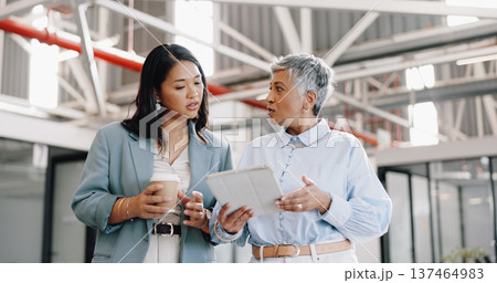 Business, tablet and mature woman with employee, talking and walking in modern office. Women, female administrator and manager speaking, conversation for schedule and leader in workplace or corporate 137464983