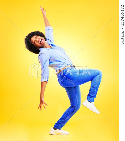 Excited, crazy and a woman in studio with fun energy, positive attitude and balance. Happy African model person isolated on yellow background for freedom dance, winner or wow celebration of success Excited, crazy and a woman in studio with fun energy, positive attitude and balance. Happy African model person isolated on yellow background for freedom dance, winner or wow celebration of success 137465172