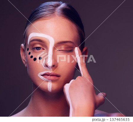 Woman, skin and paint in studio, wink and closeup for art, wellness or fantasy with cosmetic by dark background. Girl, model and facial painting for eyes, creativity or pattern with makeup for change Woman, skin and paint in studio, wink and closeup for art, wellness or fantasy with cosmetic by dark background. Girl, model and facial painting for eyes, creativity or pattern with makeup for change 137465635