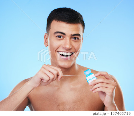 Happy man, portrait and dental floss for teeth cleaning, hygiene or grooming against a blue studio background. Male person or model smile with flossing in oral, tooth whitening or gum and mouth care Happy man, portrait and dental floss for teeth cleaning, hygiene or grooming against a blue studio background. Male person or model smile with flossing in oral, tooth whitening or gum and mouth care 137465719