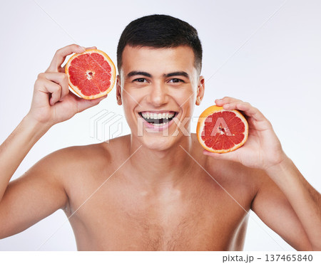 Beauty, grapefruit and natural with portrait of man in studio for health, detox or cosmetic. Vitamin c, nutrition and skincare with face of person and fruit on white background for self care and glow Beauty, grapefruit and natural with portrait of man in studio for health, detox or cosmetic. Vitamin c, nutrition and skincare with face of person and fruit on white background for self care and glow 137465840