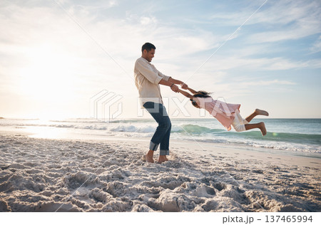 Beach, swing and father with girl child at ocean for travel, fun and bond in nature together. Freedom, celebration and parent holding hands with kid at sea happy, adventure and journey on summer trip 137465994