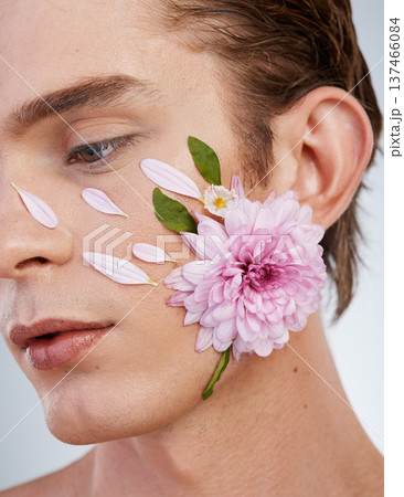 Natural, skincare and flowers on face of man in studio for spring, beauty cosmetics and creative. Glow, self love and floral with model on white background for makeup, spa treatment and wellness 137466084