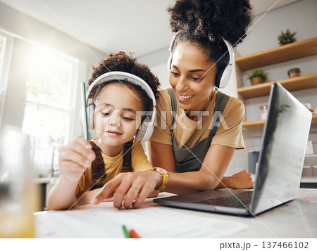 Elearning, mom and child in home with headphones, laptop and homework for online class. Computer, mother and boy working together for virtual school, help with writing and kids education in kitchen. Elearning, mom and child in home with headphones, laptop and homework for online class. Computer, mother and boy working together for virtual school, help with writing and kids education in kitchen. 137466102