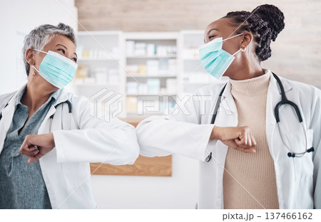 People, doctor and face mask in elbow greeting, meeting or handshake in social distancing at hospital. Women, medical or healthcare team touching arms in regulations, pandemic or health and safety 137466162