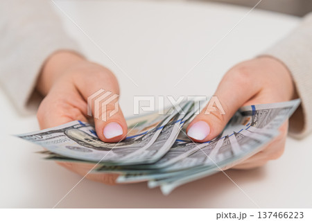 Woman counting dollar bills. Personal finance, budgeting, salary income and savings concept. Woman counting dollar bills. Personal finance, budgeting, salary income and savings concept. 137466223