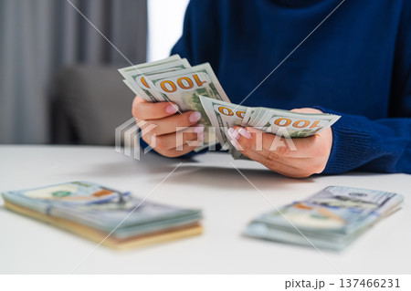 Close up of female counting dollars and arranging stacks. Business finance and cash flow concept. Close up of female counting dollars and arranging stacks. Business finance and cash flow concept. 137466231
