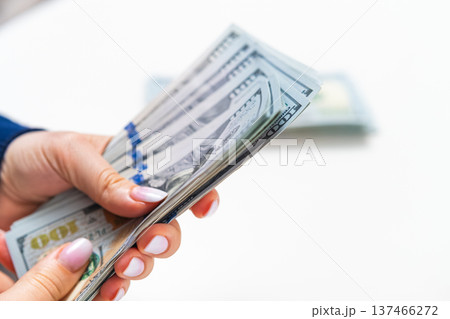 Woman showing US dollars isolated on white background. Savings and budgeting theme. Woman showing US dollars isolated on white background. Savings and budgeting theme. 137466272