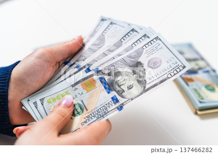 Close up of woman holding US dollar banknotes. Financial success and income concept. Close up of woman holding US dollar banknotes. Financial success and income concept. 137466282