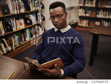 University, book and black man student reading and learning in a college for knowledge development. Serious, education and person studying research to prepare for exam or assignment in a class University, book and black man student reading and learning in a college for knowledge development. Serious, education and person studying research to prepare for exam or assignment in a class 137466573