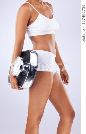 Stomach, health and woman in studio with scale for healthy body, wellness and exercise. Fitness, lose weight and closeup of person on white background in underwear for diet, detox and measuring tool Stomach, health and woman in studio with scale for healthy body, wellness and exercise. Fitness, lose weight and closeup of person on white background in underwear for diet, detox and measuring tool 137466759