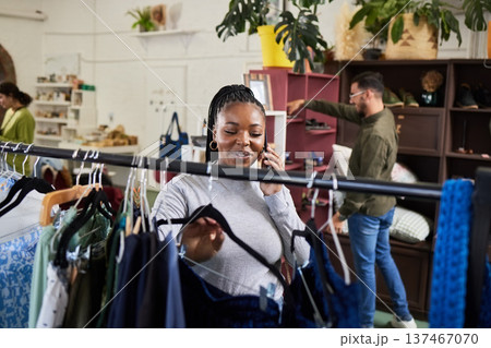 Shopping, woman and phone call for fashion talk at a retail store with sale or discount. Black person or happy customer on a smartphone for product choice, promotion or communication in a boutique Shopping, woman and phone call for fashion talk at a retail store with sale or discount. Black person or happy customer on a smartphone for product choice, promotion or communication in a boutique 137467070