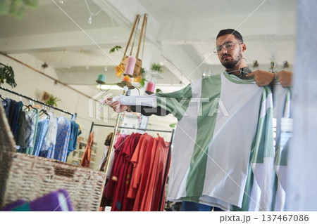 Mirror reflection, shopping and a man with choice of clothes in a store. Weekend, check and a person with a shirt in a boutique with a decision in clothing, apparel or an outfit at a shop for style 137467086