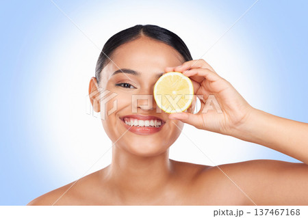 Skincare, studio portrait and happy woman with lemon for organic detox treatment, natural self care routine or facial cleaning. Vitamin C benefits, fruit and face of person smile on blue background 137467168