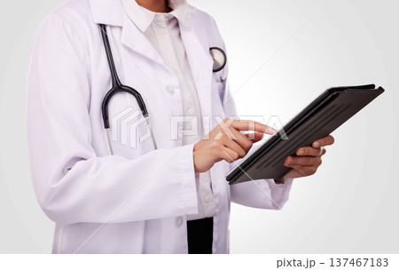 Doctor, hands and tablet in healthcare research, Telehealth or communication against a studio background. Closeup of medical person or professional on technology in online search or clinic results 137467183