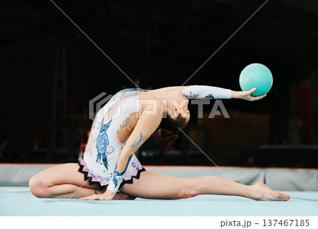 Woman, ball gymnastics and stretching in competition, performance and showcase solo concert in dark arena. Flexible dancer, rhythm and training with talent, creative skill and agile action in contest 137467185