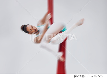 Gymnastics, woman and aerial silk with a acrobat in air for performance, sports and balance. Young athlete person or gymnast hanging on red fabric and white background with space, art and creativity Gymnastics, woman and aerial silk with a acrobat in air for performance, sports and balance. Young athlete person or gymnast hanging on red fabric and white background with space, art and creativity 137467285