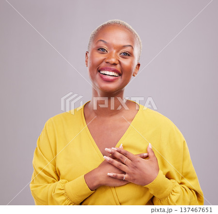Grateful, smile and portrait of a black woman in a studio with sweet, happy and positive attitude. Empathy, gratitude and young African female model with thank you gesture isolated by gray background Grateful, smile and portrait of a black woman in a studio with sweet, happy and positive attitude. Empathy, gratitude and young African female model with thank you gesture isolated by gray background 137467651