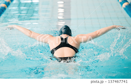 Woman, pool and swimming in water for sports fitness, race or training and practice competition. Active female person, athlete or professional swimmer in dive or lap in workout or indoor exercise 137467741