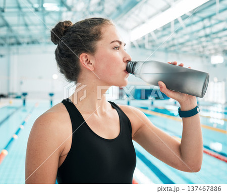 Swimmer, sports or woman drinking water to relax on break after exercise, workout or fitness training. Hydrate, thinking or girl athlete with liquid bottle for wellness or health by swimming pool 137467886