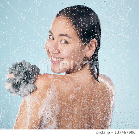 Woman, portrait and shower with water, soap and sponge for cleaning with dermatology, skincare and blue background in studio. Person, smile and washing skin and body with foam bubbles in bathroom Woman, portrait and shower with water, soap and sponge for cleaning with dermatology, skincare and blue background in studio. Person, smile and washing skin and body with foam bubbles in bathroom 137467906