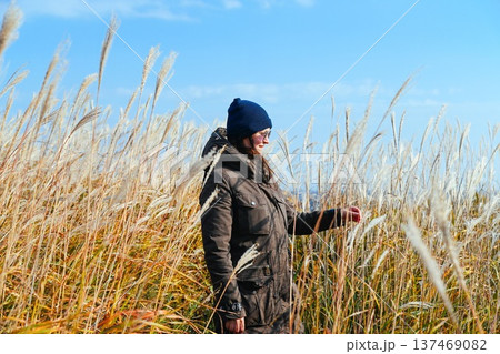Russian woman 35 years old walking through miscanthus grassland in autumn Far East Russia enjoying nature freedom mindfulness and slow solo travel 137469082