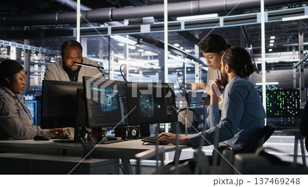 Data center admins working together, collaborating on neural network software development. Teamworking server hub colleagues implementing artificial intelligence technology in workplace, camera A Data center admins working together, collaborating on neural network software development. Teamworking server hub colleagues implementing artificial intelligence technology in workplace, camera A 137469248