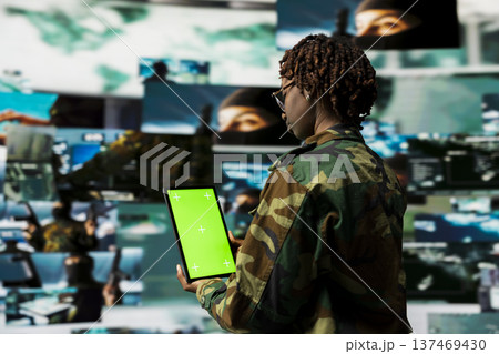 Female soldier uses isolated screen tablet application to track hostile threats. Woman in base of operations using target acquisition technology on mockup device to detect enemy location 137469430