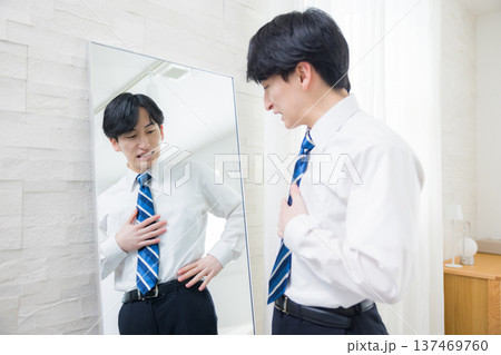 鏡を見る若い男性 137469760